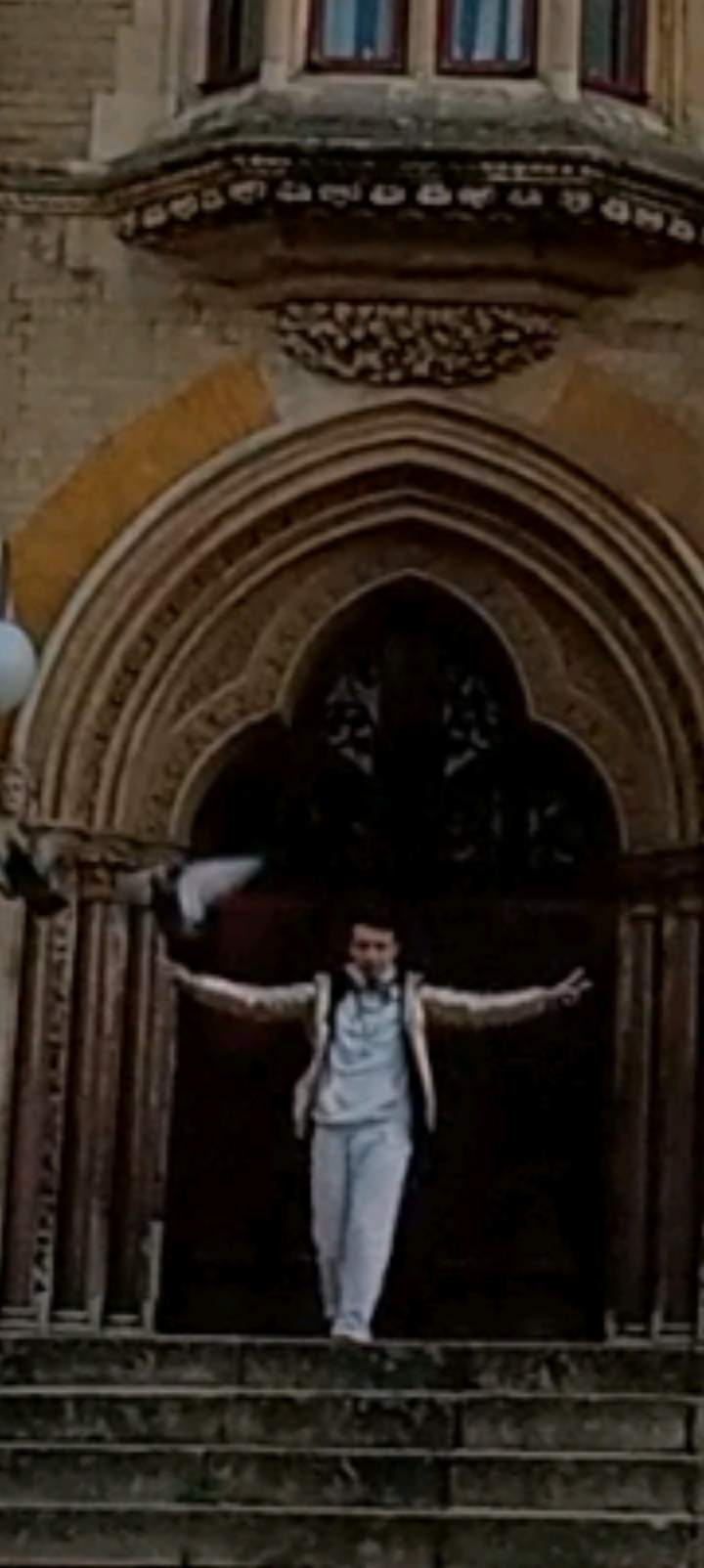 Travis Simpkins standing on the steps with arms open to the public